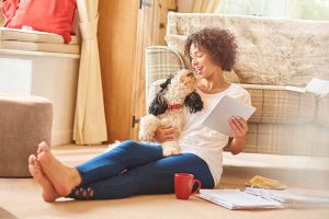 A woman holding a curly-haired dog.